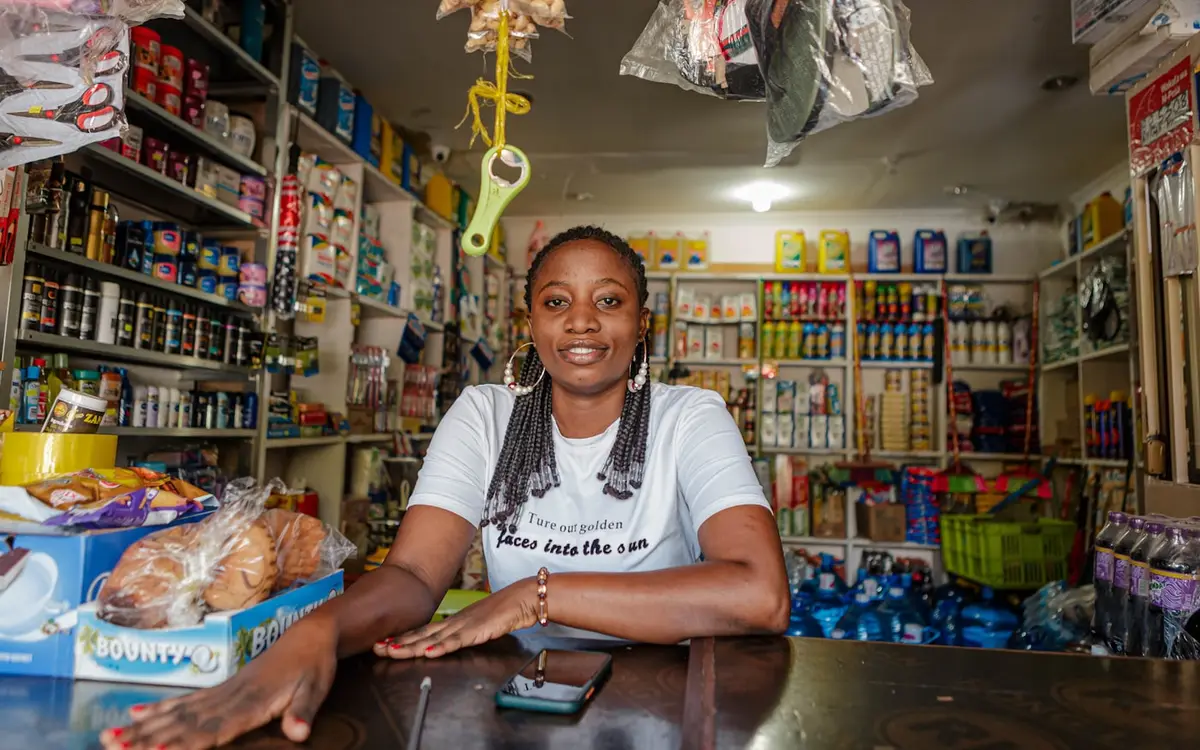 A shopkeeper behind the counter of her general store